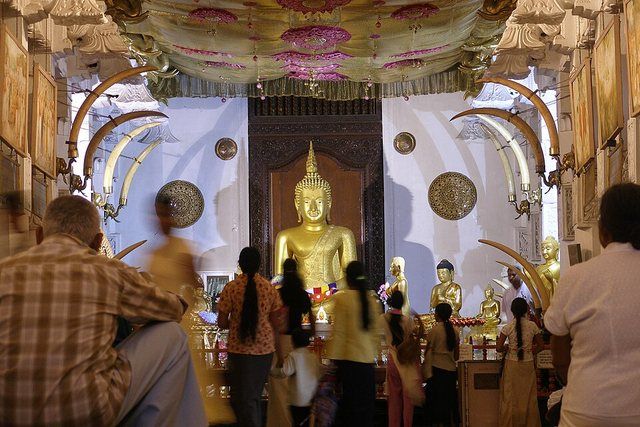 Sri Lanka, Kandy, Temple of the Tooth, Sri Dalada Maligawa: Buddhist devotees pray towards the Buddha image in Kandy Buddhist temple. Sri Dalada Maligawa or the Temple of the Sacre