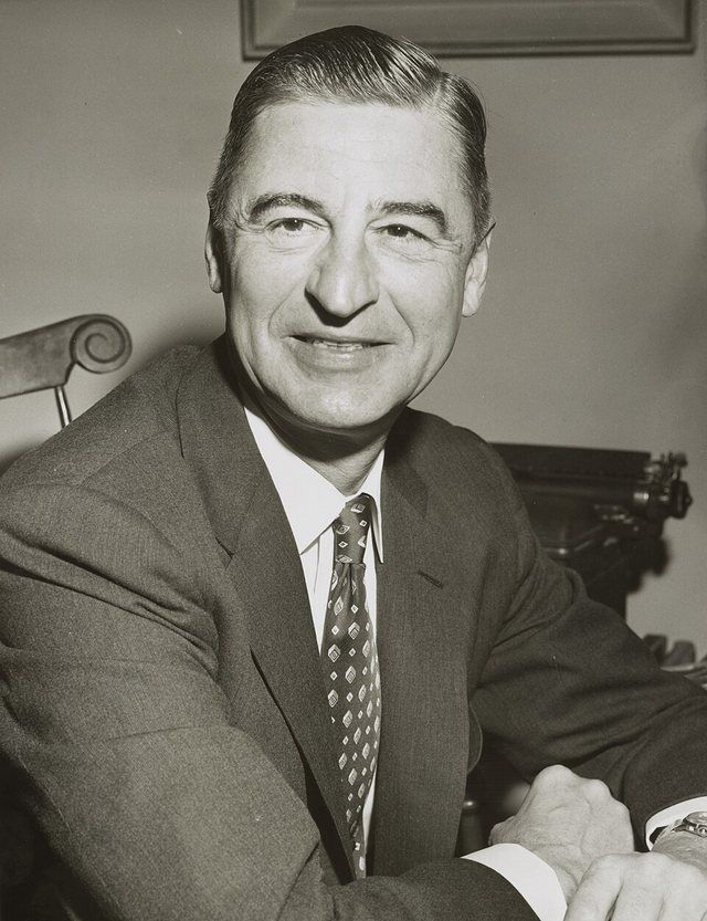 Dr. Seuss: Children's author Ted Geisel, (Dr. Seuss), three-quarter length portrait, seated at desk, facing front] / World Telegram