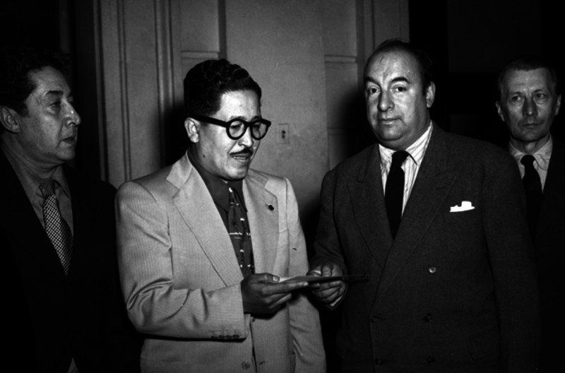 Pablo Neruda, escritor y poeta entregando papeles a un hombre